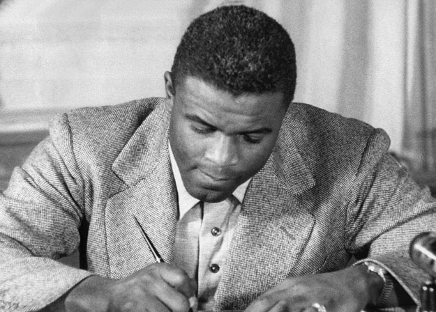 NEW YORK, UNITED STATES:  (FILES)This undated file photo shows US baseball star Jackie Robinson as he signs a then-record contract to play for the Brooklyn Dodgers in New York. Robinson has been chosen to receive posthumously the Congressional Gold Medal, the highest award Congress can bestow on a US civilian, 02 March 2005, for his accomplishments on the baseball diamond, as well as 