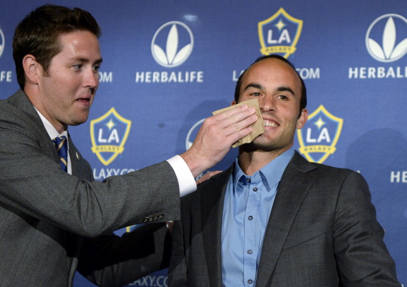 Brendan Hannan wipes lipstick from the right cheek of Landon Donovan of the Los Angeles Galaxy after he announced his retirement following the 2014 MLS season during a news conference at the StubHub Center on August 7, 2014, in Carson, California. (Photo by Kevork Djansezian/Getty Images)