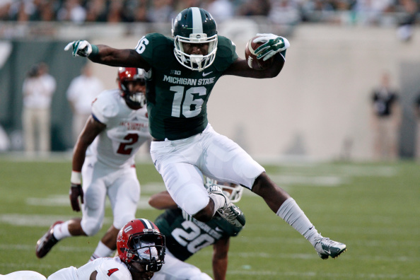 EAST LANSING, MI - AUGUST 29: Wide receiver Aaron Burbridge #16 of the Michigan State Spartans hurdles safety Folo Johnson #4 of the Jacksonville State Gamecocks on a 15-yard run during the first quarter at Spartan Stadium on August 29, 2014 in East Lansing, Michigan. (Photo by Duane Burleson/Getty Images)