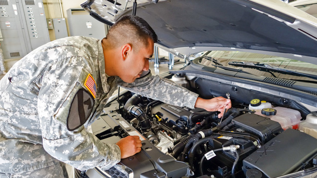 Spc. Javier Mendoza works under the hood of a 2014 GM vehicle at the Raytheon and GM training center at Fort Hood, Texas. Mendoza, a newly GM-certified automotive technician, hopes to find work at a GM dealership in his hometown, Houston, Texas. Photo by Pat McKenna/Raytheon