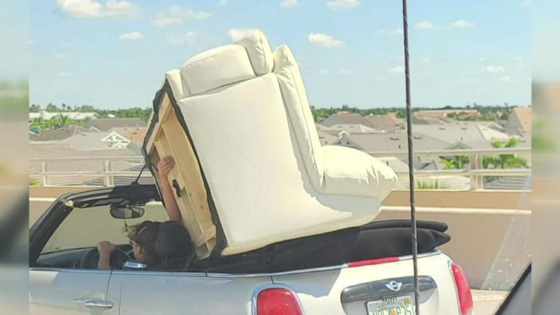 SEE IT: Woman Hauls Couch On Convertible MINI Cooper, Holds It Up With Hand!